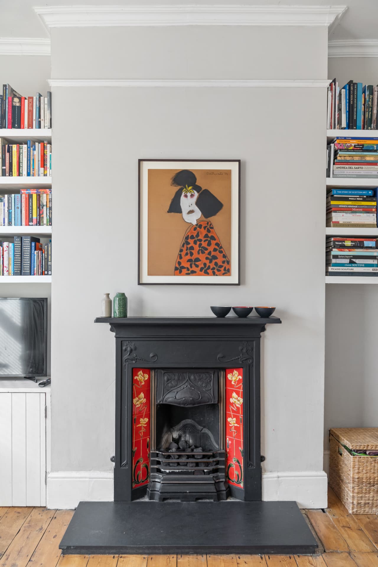 Victorian fireplace with original tiled inserts and framed artwork